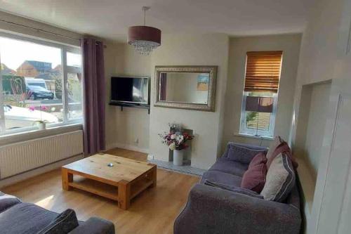 a living room with a couch and a coffee table at Modern 4 bedroom house in Weymouth Sunny Corner in Weymouth