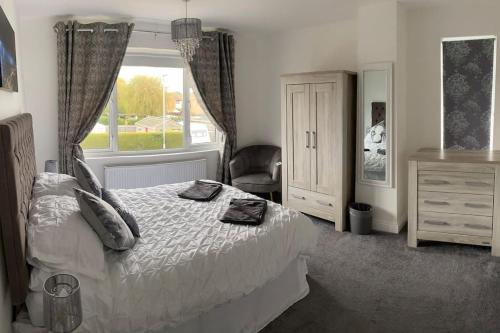 a bedroom with a bed and a window and a chair at Modern 4 bedroom house in Weymouth Sunny Corner in Weymouth