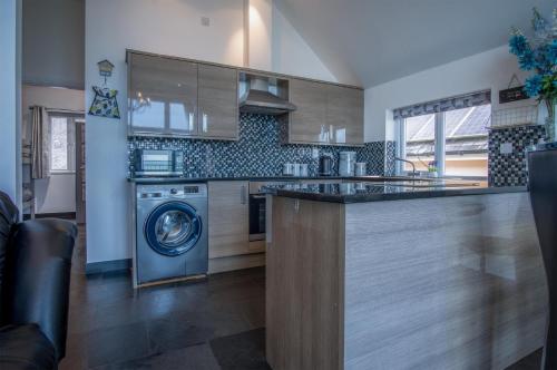 a kitchen with a washer and a dishwasher in it at Nautilus - 2 Bedroom Apartment - Pendine in Pendine