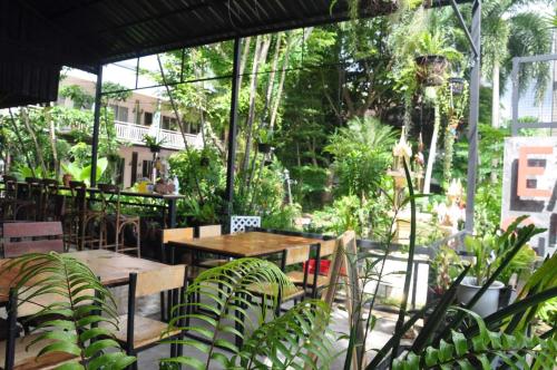 a patio with tables and chairs and plants at Eat n Sleep in Phuket Town