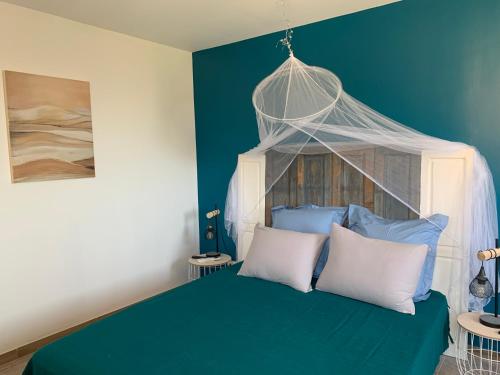 um quarto azul com uma cama com almofadas brancas em Casa Rosalinda em Figari