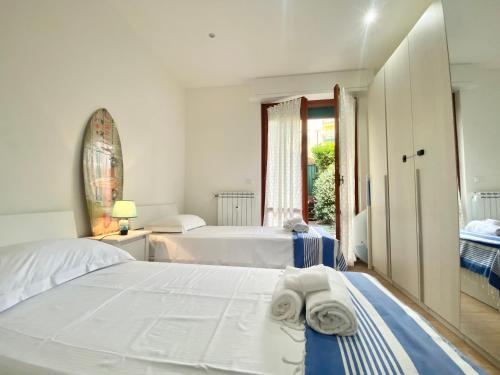 Un dormitorio blanco con dos camas y una ventana. en CasaViva - Trilo with patio in Santa Margherita L., en Santa Margherita Ligure