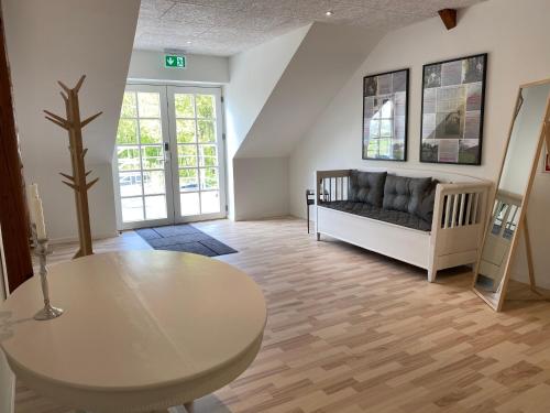 een woonkamer met een bank en een tafel bij Luksuslejlighed til 8 personer i hjertet af Sønderjylland in Branderup