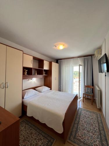 1 dormitorio con 1 cama grande y TV en Apartments and Rooms Jasna, en Hvar