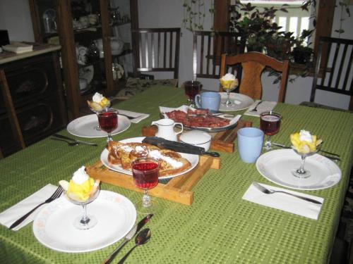 a table with plates of food and glasses of wine at Phoenix House B&B in Stettler