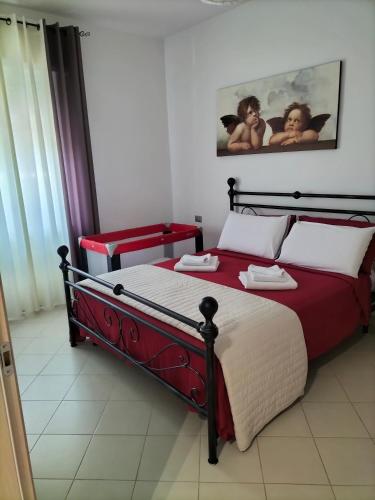 a bedroom with a large bed with red sheets and white pillows at Villa Rosina in Rho