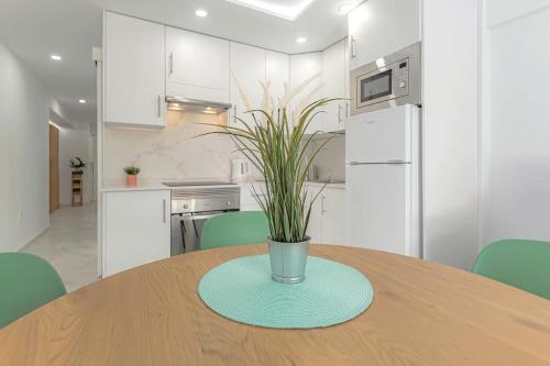 a kitchen with a wooden table with a vase on it at Apartamento SAN EUGENIO ,, LOS GARANIOS” in Adeje