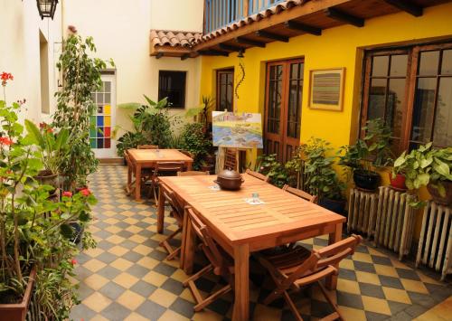 a patio with wooden tables and chairs and plants at Hostal Rio Amazonas in Santiago