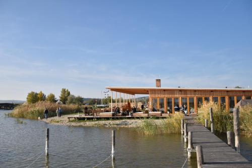 a building with a dock next to a body of water at Seevilla Matilda direkt am Ufer in Jois