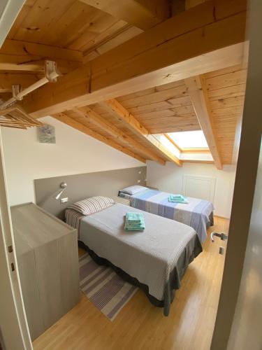 two beds in a room with wooden ceilings at Apartments Bea in Lovran
