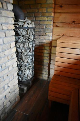 a fireplace in a room with a brick wall at Kaimukas - namelis prie ežero keturiems in Dvarčėnai