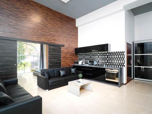 a living room with a black couch and a fireplace at "Apollo" - domek, apartamenty i pokoje z klimatyzacją in Krynica Morska