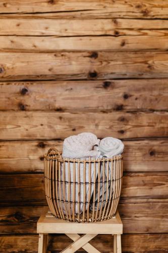 a basket of towels sitting on a wooden stool at Vienkiemio Oazė - Namelis Prie Upelio in Galvokai