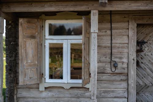 a window on the side of a wooden house at Vienkiemio Oazė - Namelis Prie Upelio in Galvokai