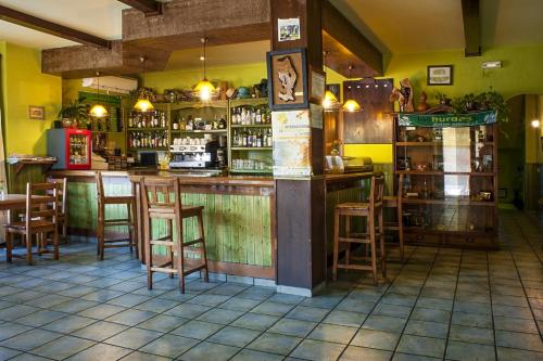 un bar en un restaurante con taburetes de madera en Hotel Rural Cristania, en Caminomorisco