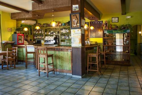 bar w restauracji z drewnianymi stołkami w obiekcie Hotel Rural Cristania w mieście Caminomorisco