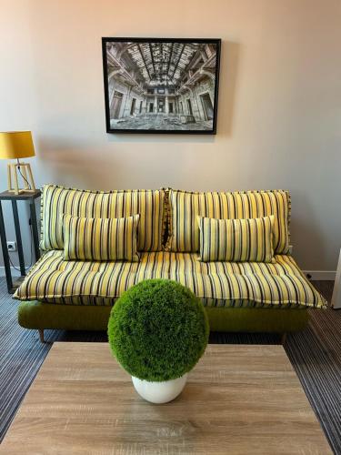 a green couch in a living room with a plant at Le Nouvel Hôtel in Oyonnax