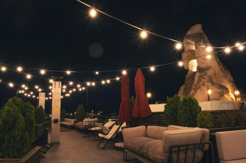 a patio with chairs and lights at night at Carus Cappadocia in Goreme
