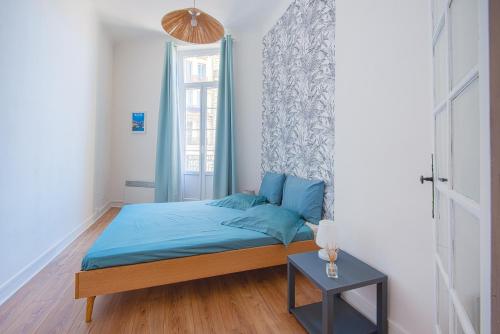 a bedroom with a bed with blue sheets and a window at Le Balcon du Vieux-Port-Amazing Sea View-100m2 in Marseille
