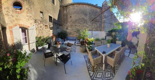 an outdoor patio with tables and chairs in a building at L'Ancienne Boulangerie in Caunes-Minervois