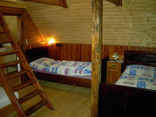 sypialnia z 2 łóżkami w drewnianym domku w obiekcie Chalet Tatranec w mieście Stwoła