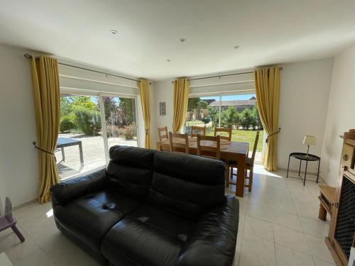 un salon avec un canapé en cuir noir et une table dans l'établissement Beautiful 4 bedroom country cottage sleeps 7, à Saint-Cybranet