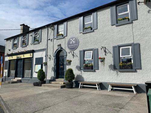 a building with two benches in front of it at Madelines Accommodation in Tinahely