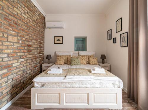 a bedroom with a large bed with a brick wall at Villa Bella in Badacsonytomaj