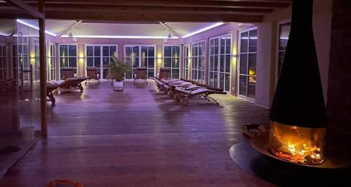 a large room with benches and tables and windows at Hotel Molitors Mühle in Eisenschmitt
