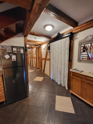a kitchen with a black refrigerator and wooden floors at Agroturystyka Łysa Góra in Jelenia Góra