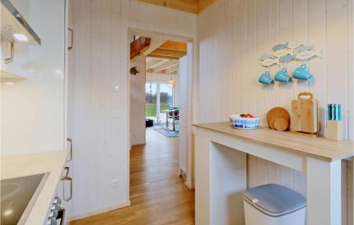 eine Küche mit weißen Wänden, Holzböden und einer Theke in der Unterkunft Lieblingsplatz in Olpenitz