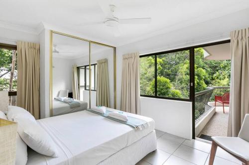 a bedroom with two beds and a large window at Tranquil Noosa at its best Beach, Bush, Good Food. in Noosa Heads