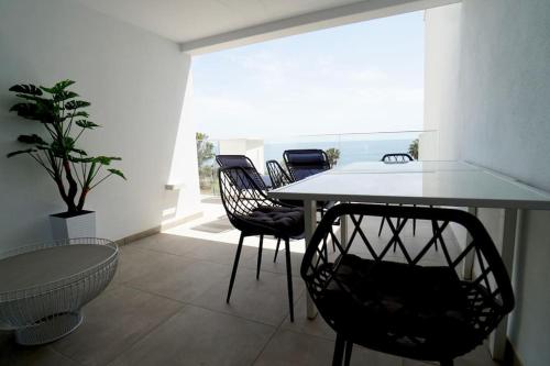 jadalnia ze stołem i krzesłami oraz oknem w obiekcie Deluxe sea view apartment with a swimming pool w mieście Benalmádena