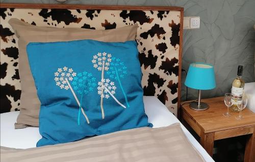 a blue pillow sitting on a bed with a table at Boerderij Hazenveld in Kockengen