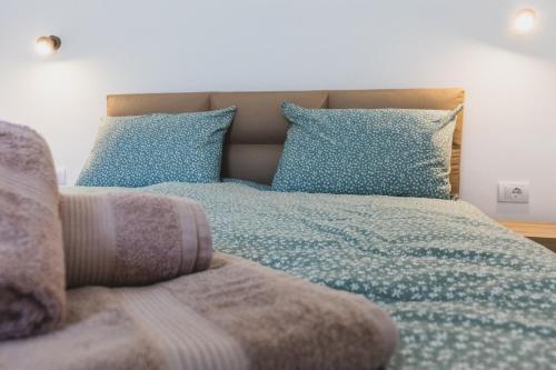 a bedroom with a bed with blue pillows at ALFA Apartmani in Subotica