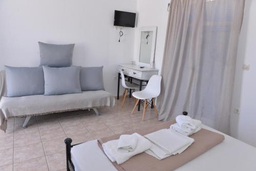 a bedroom with a bed and a desk and a couch at Papikinou Studios in Adamantas