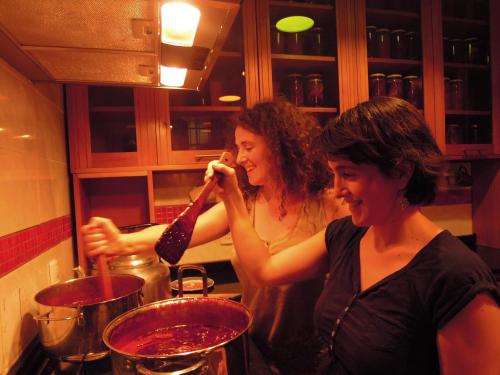 two women standing in a kitchen preparing food at Hostal Rio Amazonas in Santiago