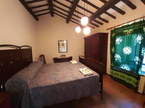 um quarto com uma cama e uma grande janela em Agriturismo del Frontino - Ca' Benvenuto em Acqualagna