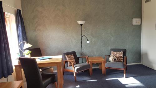 a dining room with a table and chairs with a cat sitting in one chair at Boerderij Hazenveld in Kockengen