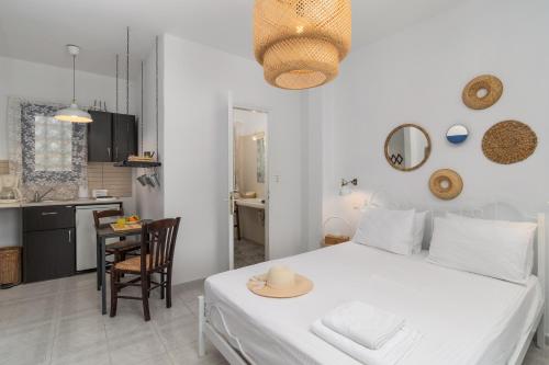 a bedroom with a white bed and a kitchen at Anamnisi Studio in Adamantas