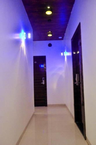 a hallway with blue lights on a white wall at THE BEST HOTEL MUMBAI in Mumbai