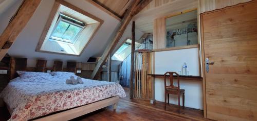 a bedroom with a bed and a large window at Le Moulin Hodoux in Luynes