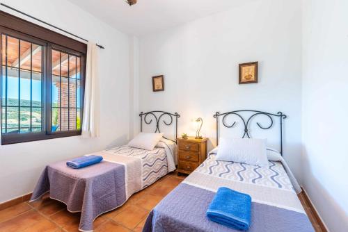 sypialnia z 2 łóżkami i oknem w obiekcie Mirador de la Encina w mieście Valle de Abdalagís