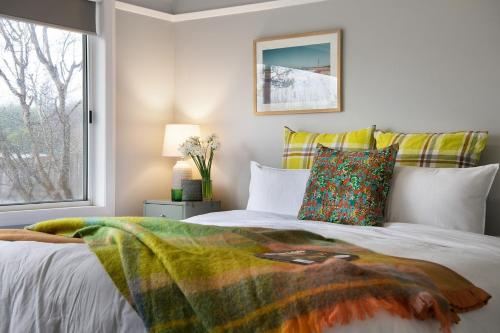 a bedroom with a bed with a blanket on it at Little Olive in Kyneton