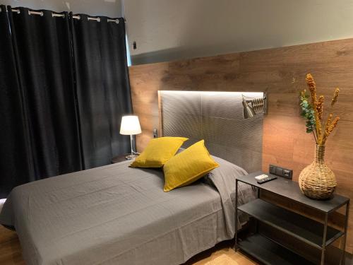 sypialnia z łóżkiem z żółtymi poduszkami i stołem w obiekcie Lost & Found - Guesthouse & Suites w Albufeirze
