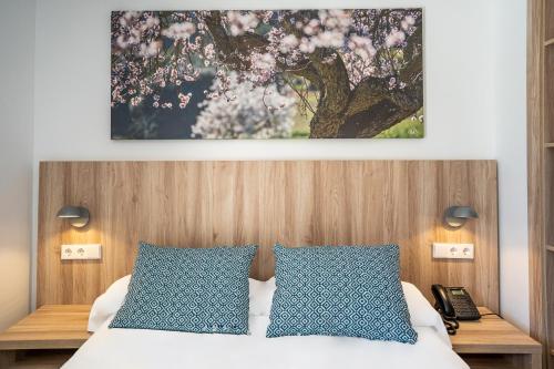 a bedroom with a bed with blue and white pillows at INNER Hotel Rupit "Adults Only" in Cala d´Or