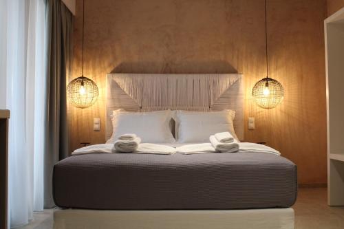 elia boutique hotel في بارغا: غرفة نوم بسرير كبير عليها منشفتين
