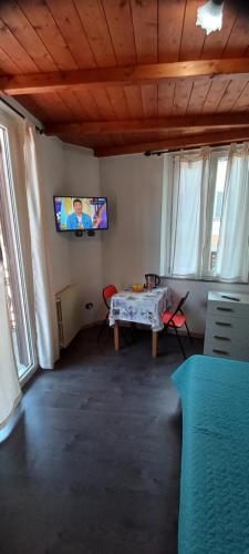 a living room with a table and a tv on the wall at Casa Mango in Stresa