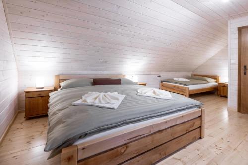 a bedroom with a large bed with two towels on it at Drevenica Irenka in Zuberec