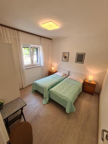 a bedroom with two beds and a window at Apartments Viktorija in Pula